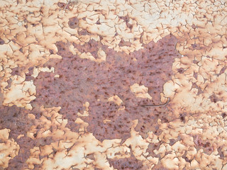 Rust-stained peeling white paint on very Rusty grunge metal surface; texture