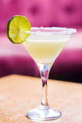 Yellow coctail with lime, margarita cocktail with salty rim