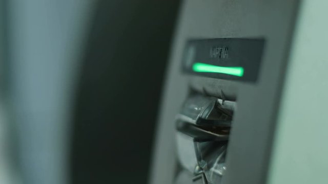 Close up shot of man hands putting the credit card to the ATM in the airport.