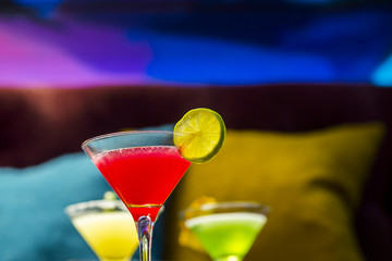 Three colorful cocktails in martini glasses