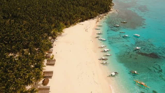 Aerial view of beautiful tropical island Daco with white sand beach. View of a nice tropical beach from the air. Beautiful sea, resort. Seascape: Ocean and beautiful beach paradise. Philippines. 4K