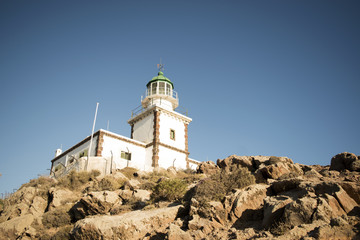 Fototapeta na wymiar Lighthouse on Side of Cliff