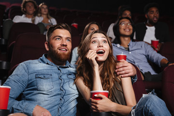 Surprised young couple sitting at the cinema