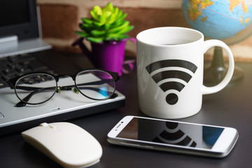 Table of office stuff Business man with Laptop, Wireless mouse, Smart phone, Glasses and Coffee Cup WIFI symbol.Concept office Business man workplace.