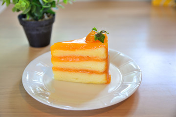 Orange cake placed on a plate on a wooden table
