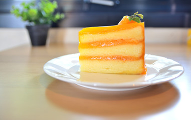 Orange cake placed on a plate on a wooden table