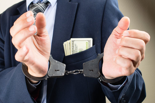 arrested businessman in handcuffs. Businessman bribetaker or briber. Concept of fraud, detention, crime and bribery
