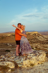 Loving couple on a rock top.