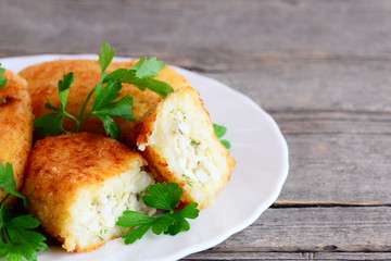 Veggie patties with egg filling on a white plate. Fried patties made with mixed boiled vegetables. Easy homemade vegetarian recipe. Rustic style. Closeup