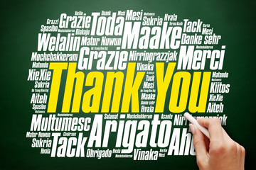 Hand writing Thank You Word Cloud in many languages on blackboard, presentation background