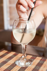 hand of the girl drinking Martini from a glass with ice