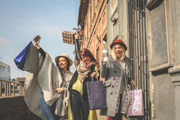 Three best friends walking on the street . Young female best friends doing shopping on the streets.