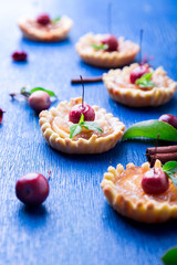 Apple caramel little tarts on blue rustic background. French tatin with paradise apple