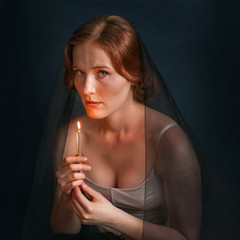 Obraz premium Woman with candle under veil. Halloween photo