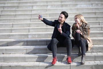 Fototapeta premium A couple of friends are sitting on the steps
