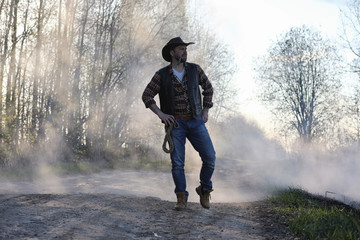 A cowboy in a thick smoke on the road