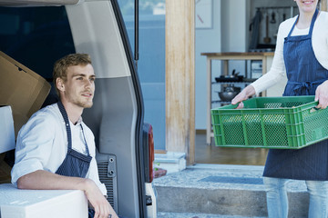 Caterers loading vehicle with prepared food