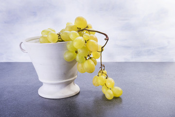 Ceramic pot full of sweet yellow fruit grapes