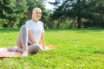 Concentrated mature woman sitting on the mat