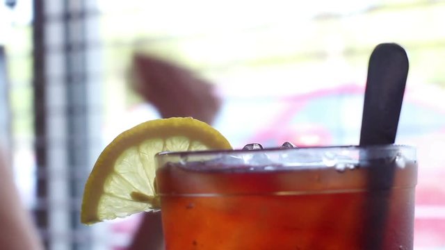 Lemon sitting ontop of glass of Iced Tea in restaurant