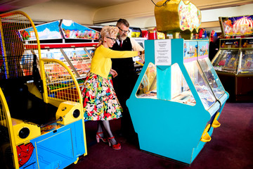 Couple enjoying themselves in amusement arcade, Bournemouth, England