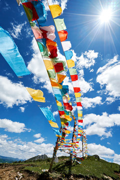 Rows of colourful prayer flags against blue sky, Zhagana, Gansu, China