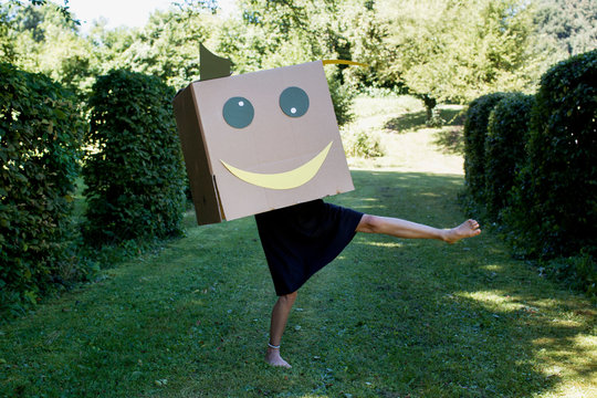 Girl with smiley face box over head