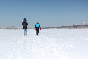 Man, woman and the child walking on the snow river in the winter, Siberia, Russia