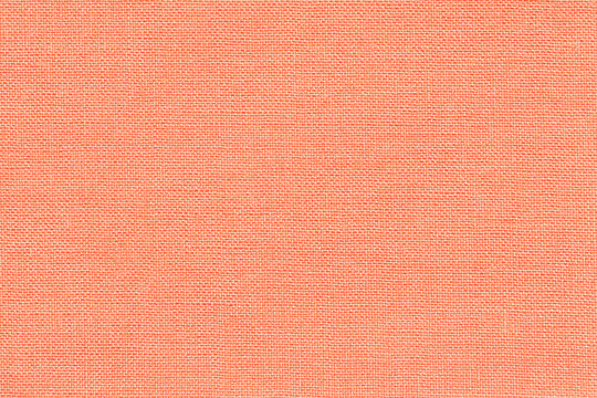 Light coral background from a textile material with wicker pattern, closeup.