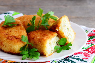 Crispy vegetable patties with egg filling on a white plate. Fried patties made with mix boiled vegetables. Simple homemade vegetarian recipe. Rustic style. Closeup