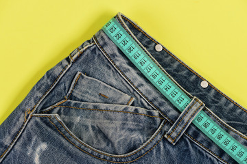 Top part of denim trousers isolated on yellow background.