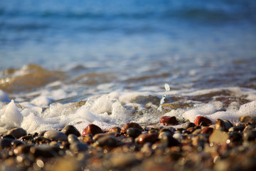 Waves washing over gravel beach, macro shot.