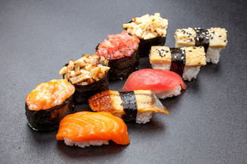 Many different sushi on a black table, Japanese food © segenvitaly