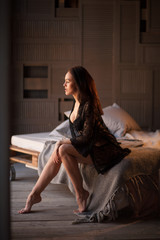 Fototapeta premium Sexy brunette woman posing in elegant lingerie, looking at camera. Girl with perfect body lying, relaxing.