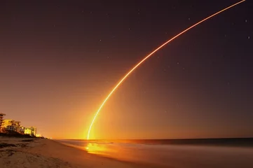 Raamstickers Space rocket lunch at the Atlantic Ocean shore in Florida at night. © Norbert