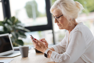 Nice professional businesswoman using her smartphone
