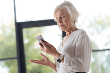 Unhappy irritated woman looking at her phone