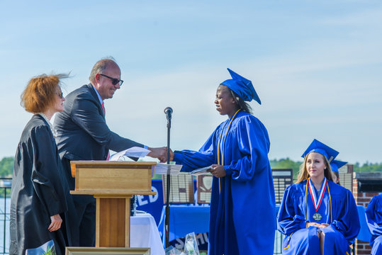 Student shaking hands with senior man at graduation ceremony
