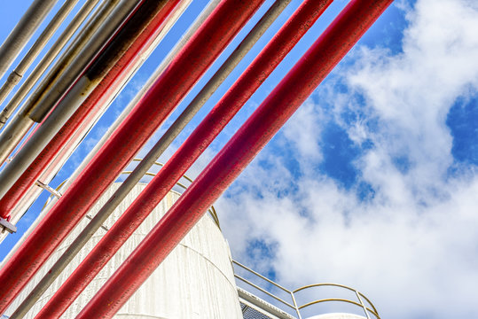 Low angle view of industrial piping and storage tanks at biofuel plant