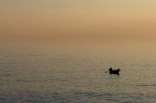 Fisherman on water at sunset, Camogli, Liguria, Italy