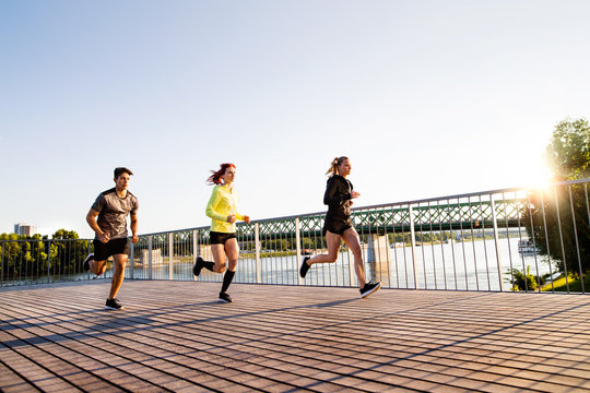 Young Athtletes In The City Running At The River.