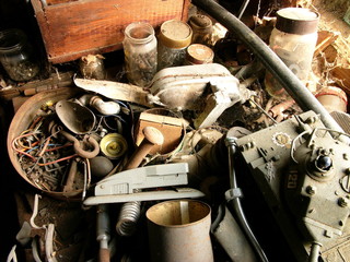 Alter Kram mit Bürohefter und Spielzeugpanzer in einer alten verlassenen Werkstatt in der Scheune...