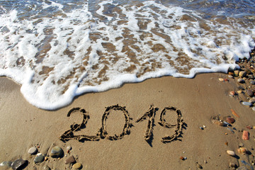 New year 2019 written in sand.