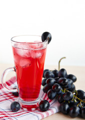 Fruit juice with ice in a glass, a bunch of grapes