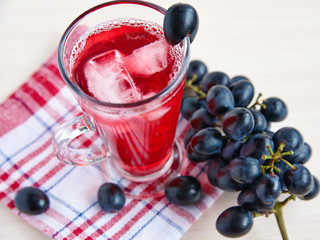 Grape juice with ice and a bunch of black grapes