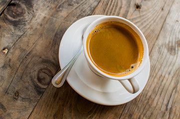 Hot Americano coffee in white cup on wooden table. This is how the makers of hot water mixed into the espresso. Americano is for those who prefer black coffee.