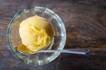 Glass bowl with tasty color ice cream on wooden table