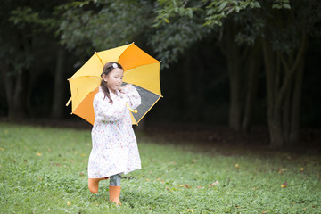 Happy little girl walking with an umbrella