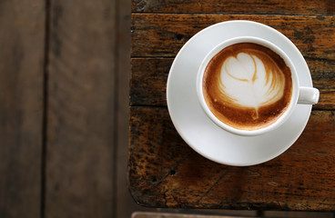 Hot latte coffee On the old wood table in the morning.Copy space for your text.