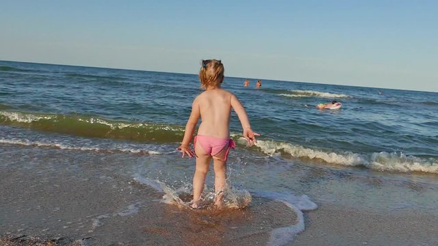 Little girl running waterfront sea